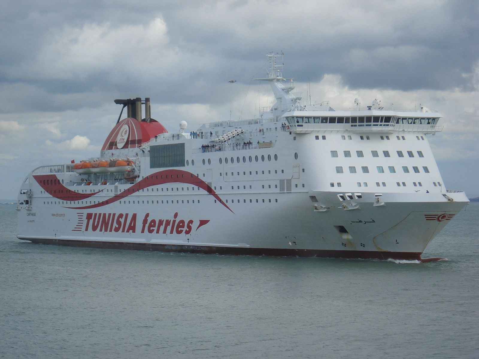 Ferry blanc et rouge de la compagnie Tunisia Ferries entrant dans le port de La Goulette, près de Tunis