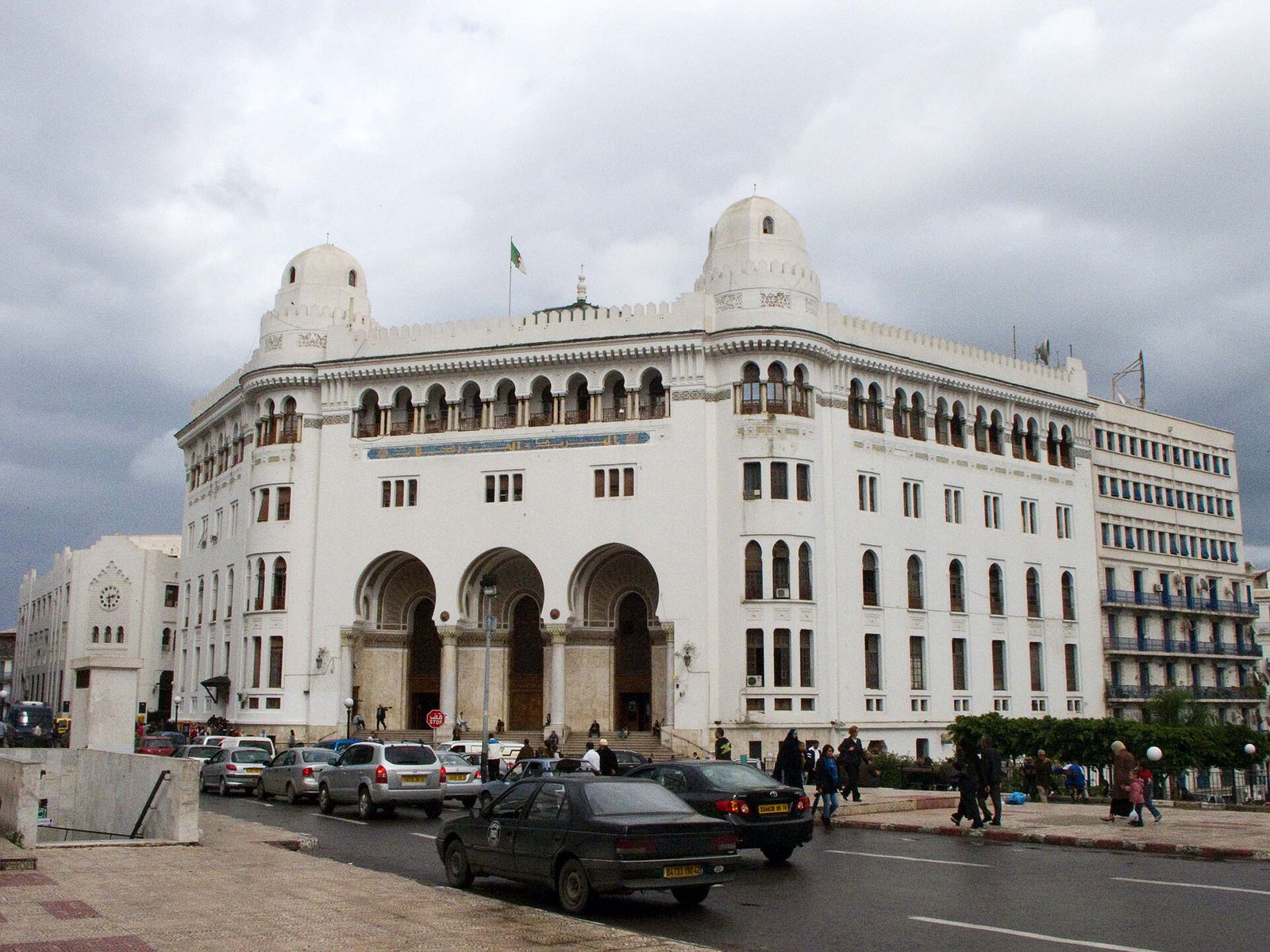 La Grande Poste d’Alger, bâtiment blanc de style néo-mauresque, sous un ciel nuageux