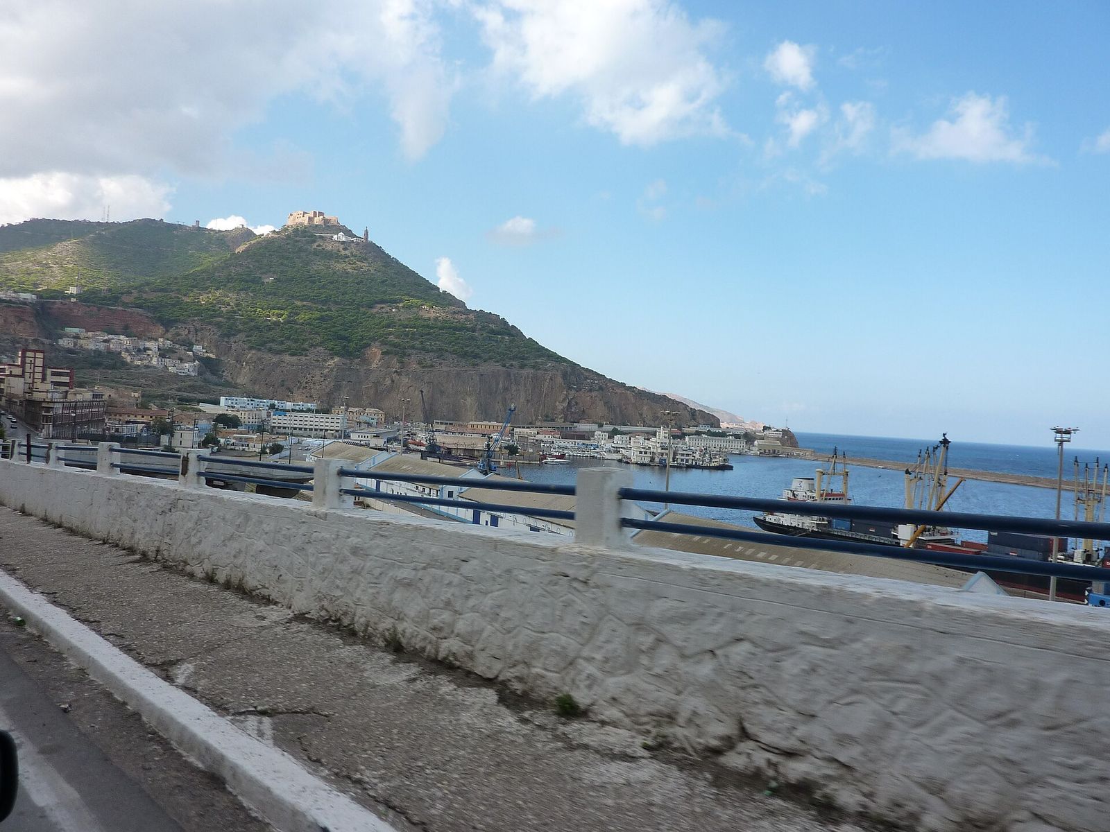 Vue sur le port d’Oran depuis une corniche, avec la montagne qui domine la ville en arrière-plan